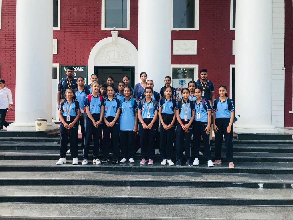 Girls' team in sports uniform on the school steps