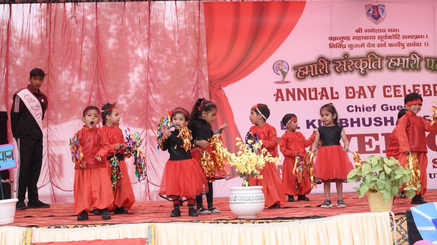 Young students in red costumes performing at the Annual Day