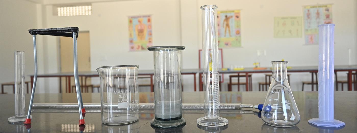 Glass beakers and measuring cylinders on a science lab bench